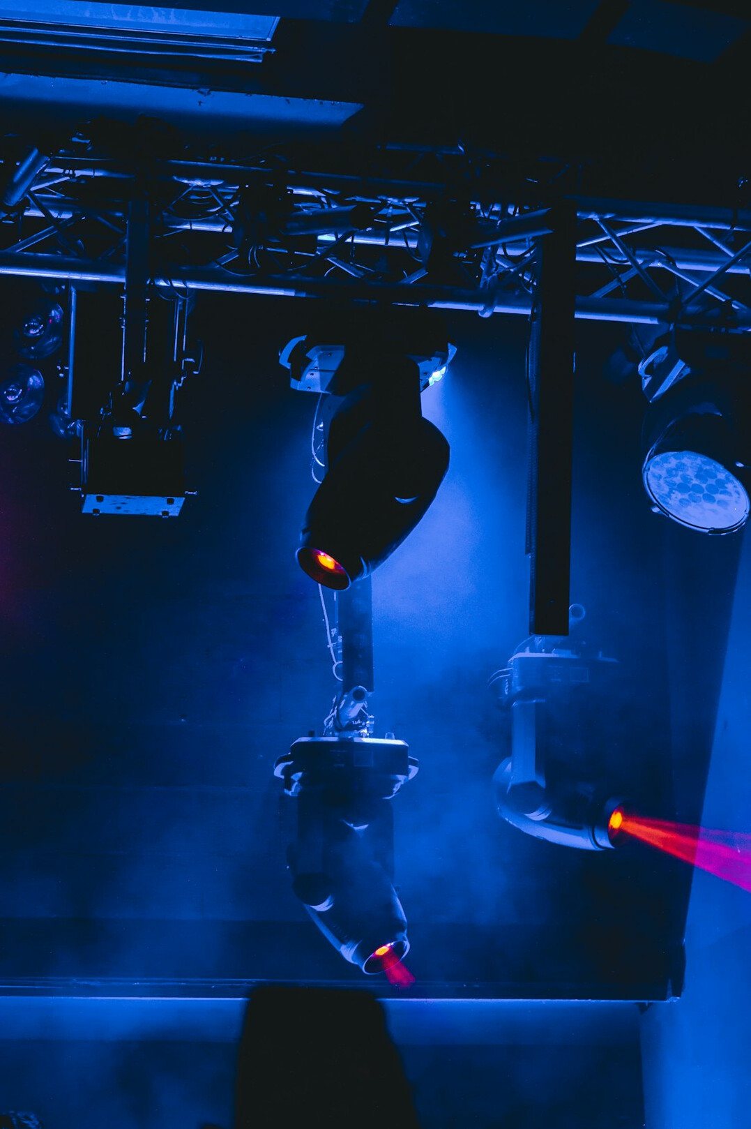 Studio lighting rig with soft boxes and spotlights hanging over a set
